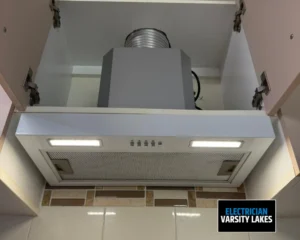 Kitchen rangehood with dual light fixtures mounted above stove