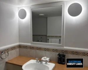 Bathroom sink with large mirror and wall-mounted LED lighting